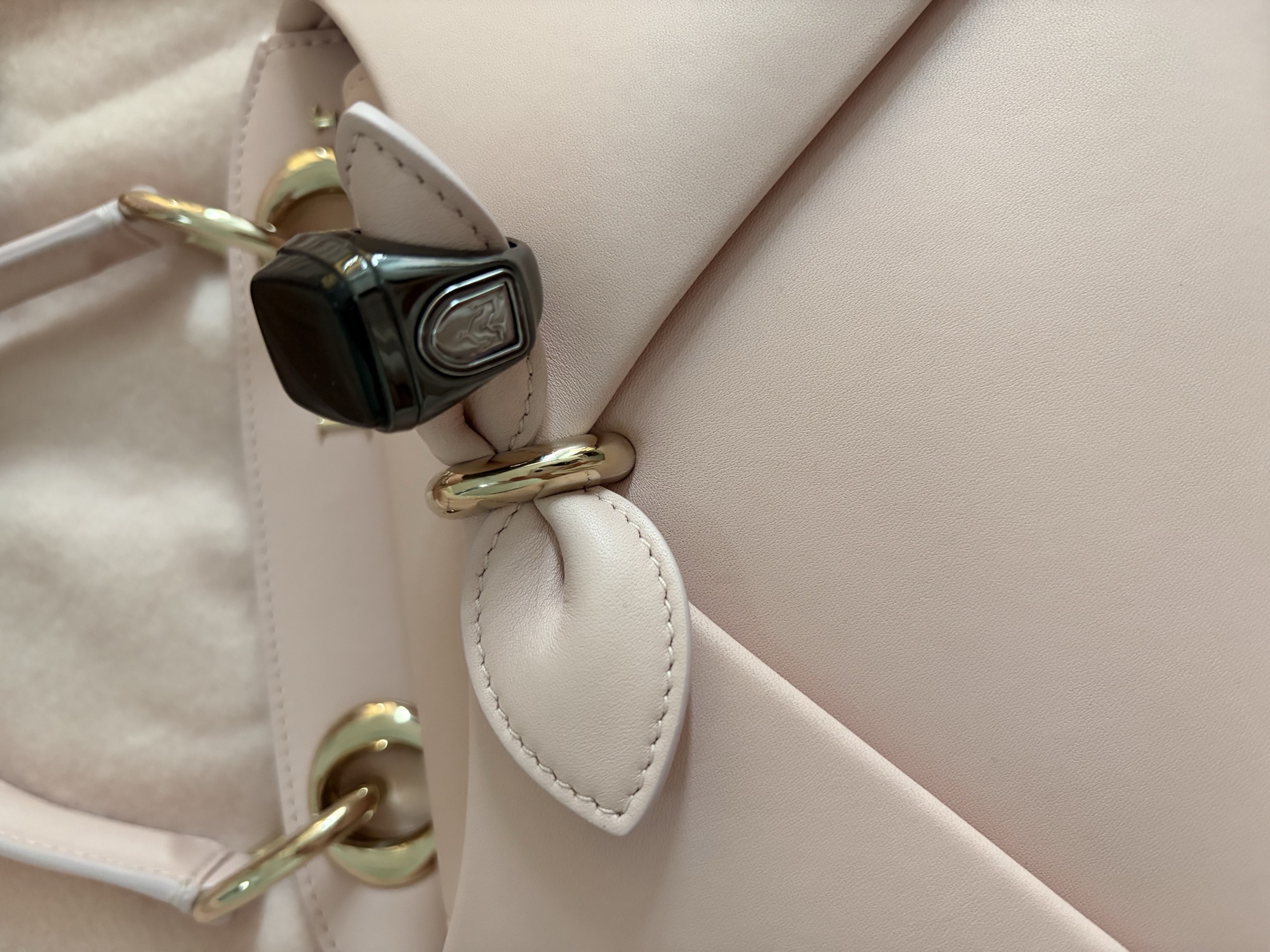 Zikr Vibe Ring photographed on a blush bag strap